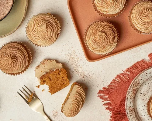 Cupcakes à la citrouille avec glaçage, l’un coupé en deux, sur une table